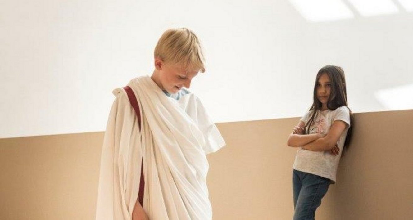 Junge mit römischer Tunika bekleidet, Mädchen im Hintergrund