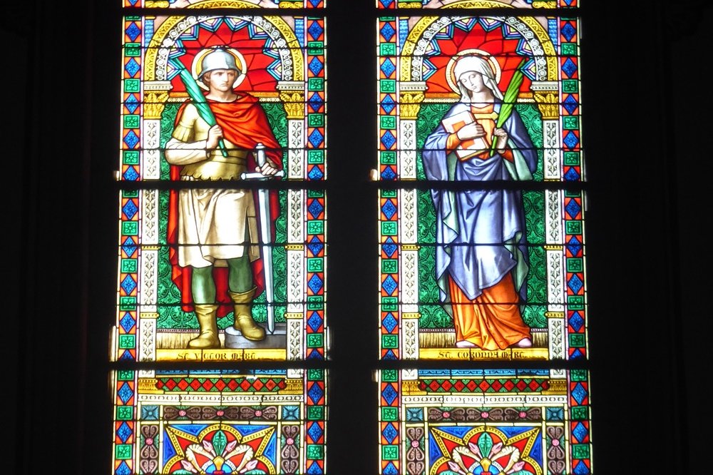 Saints Victor and Corona on the lateral stained glass windows, Levico Terme chiesa del Santissimo Redentore Vetrate laterali Santi Vittore e Corona, Foto: Syrio / CC BY 4.0